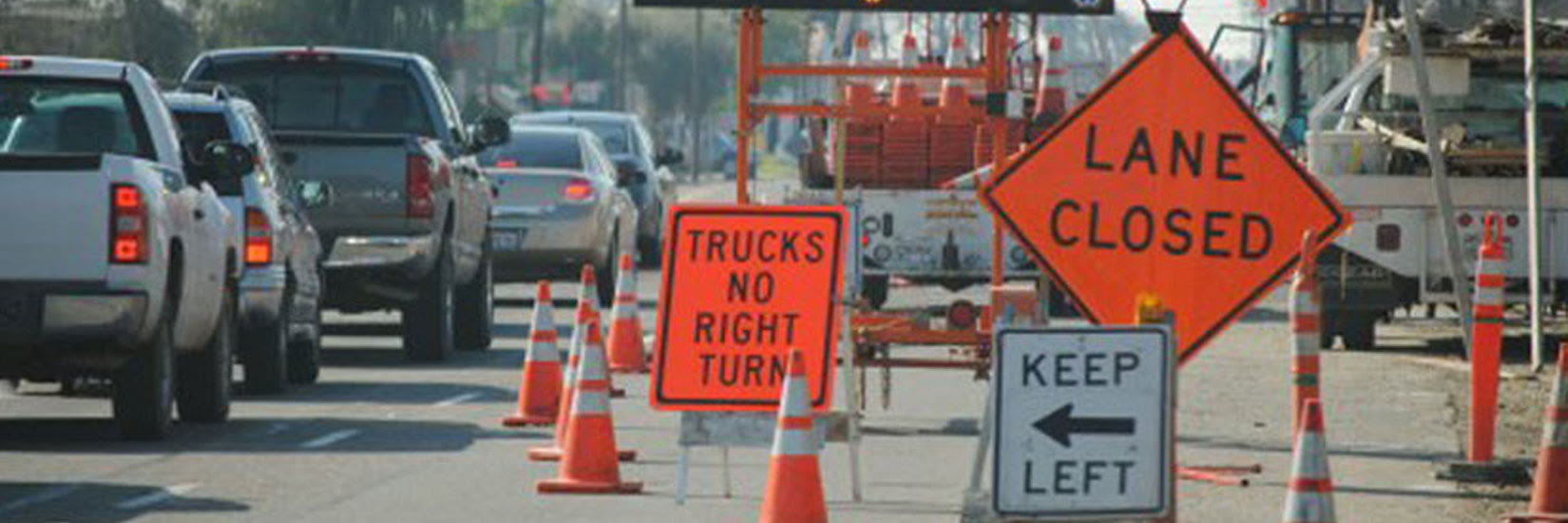 Lane Closed and Keep Left signs with cones directing traffic past a work zone