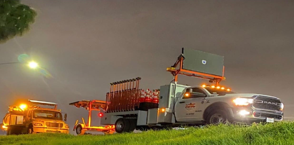 KRC Safety trucks with an arrow board and cones working a road at night